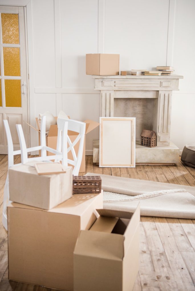 Cardboard boxes and furniture in empty room, relocation concept