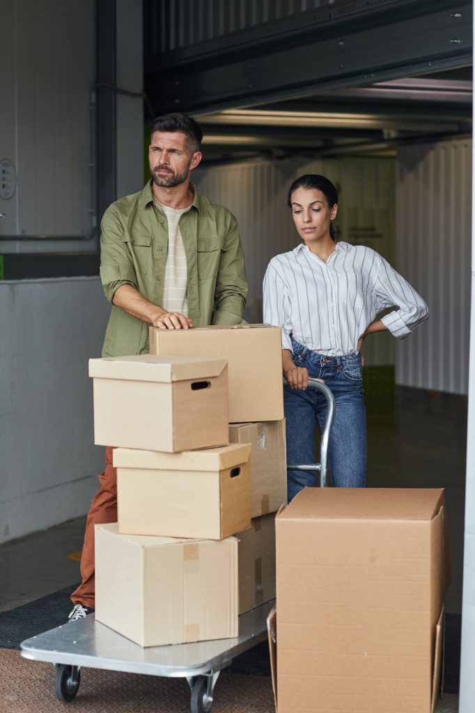Couple Moving Boxes in Storage Unit