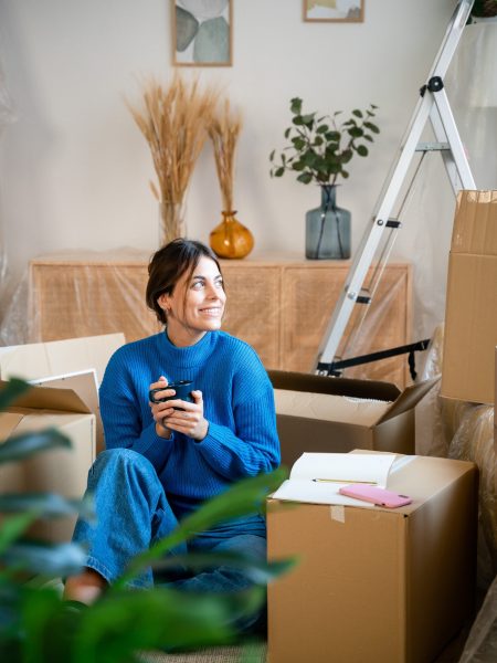 Female in casual clothes sitting during relocation into new apartment